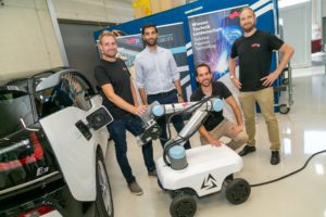 Die Demo-Version des E-Laderoboters. (v.l.) Bernhard Walzel, Ehsan Zadmard (ALVERI), Konstantin Mautner-Lassnig (ARTI Robots) und Helmut Brunner ©Robert Frankl/ TU Graz