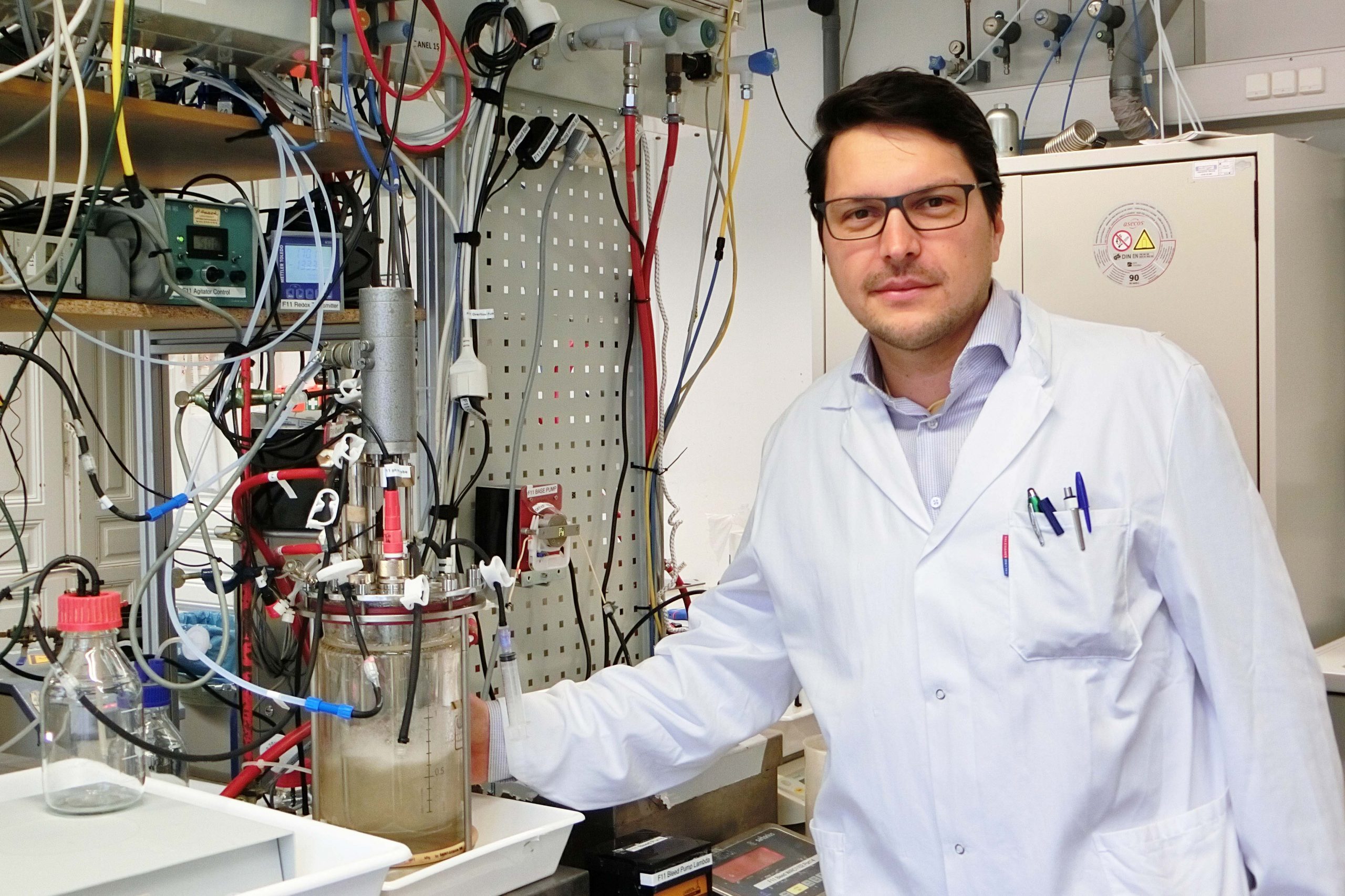 Stefan Pflügl im Labor. Links von ihm ein Bioreaktor. ©TU Wien